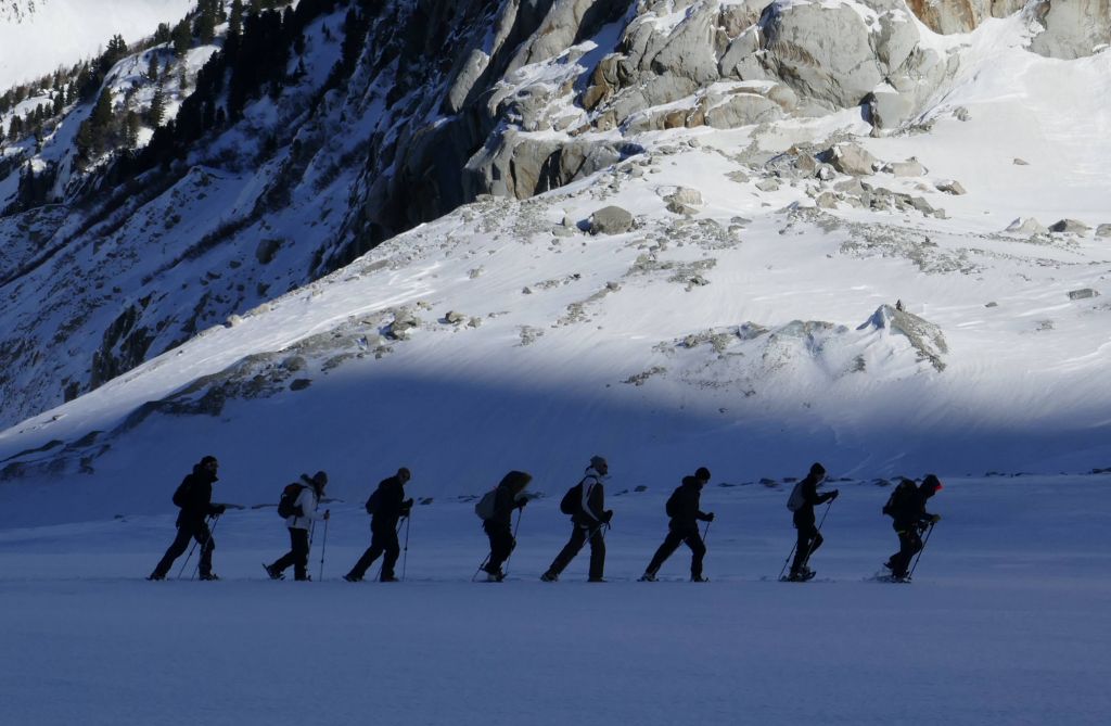 some people walked up the glacier in snow shoes